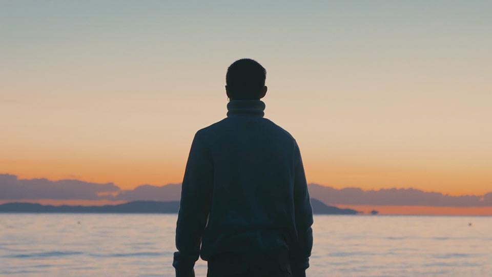 Man at sunrise in front of the sea