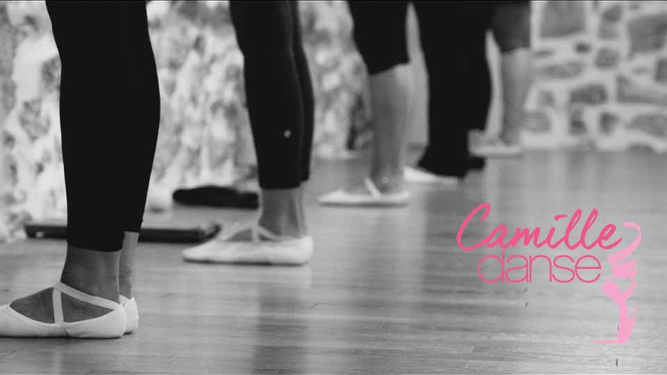 Ballet dancers' legs and feet facing a wall