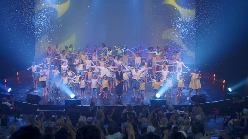 Wide shot of a group on dancers on stage